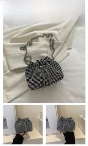 Detail of black drawstring bucket bag with silver rhinestones and pearl accents