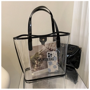 Detail of transparent PVC tote bag with black inner pouch and matching leather straps