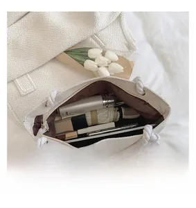 Spacious interior of white tweed tote bag showing items like umbrella and phone