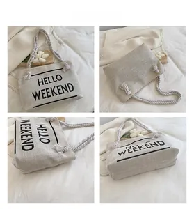 Detail view of large canvas tote bag with rope handles and Hello Weekend lettering