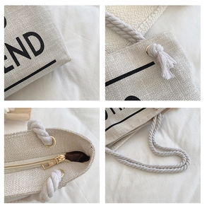 Detail view of off-white canvas tote bag featuring hemp rope handles and gold zipper closure