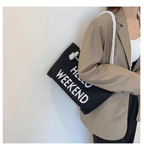 Detail of black canvas tote bag with Hello Weekend print and white rope handles