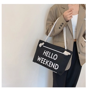 Close-up of black canvas tote bag with Hello Weekend print and white rope straps