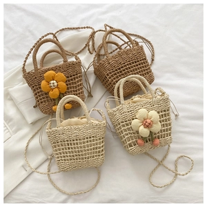 Close-up of handmade straw bucket bags with floral accents and drawstring lining
