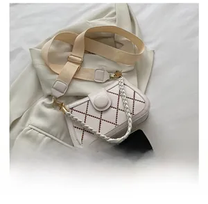 Detailed view of mini white crossbody bag with lattice stitching and phone size comparison
