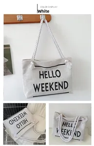 Detail view of white canvas tote bag with thick rope handles and Hello Weekend print
