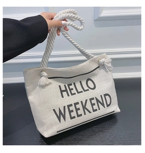 Detail of canvas tote bag with thick rope handles and Hello Weekend text print