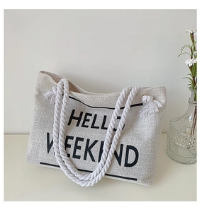 Close-up of HELLO WEEKEND canvas tote bag with woven cotton rope handles and floral decor