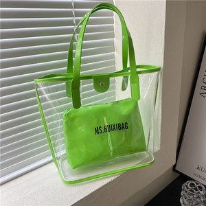Neon green transparent PVC tote bag with matching inner pouch on white windowsill