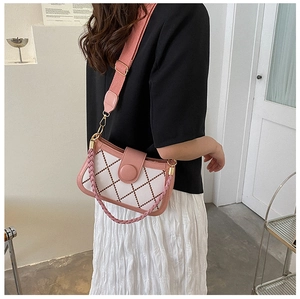 Close-up of pink and white crossbody bag with diamond lattice pattern and woven strap