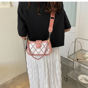 Pink and white quilted crossbody bag with a trendy fabric strap shown on model