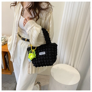 Detail of black pleated bubble shoulder bag with yellow flower charm and chunky chain