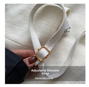 Detail of adjustable white PU leather shoulder strap with gold square buckle on small bag