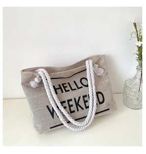 Detail of beige linen tote bag with cotton rope handles and Hello Weekend print
