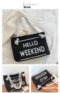 Detail of black canvas tote bag with HELLO WEEKEND print and white rope tassel handles