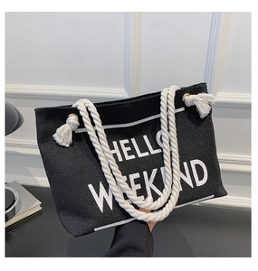 Detail of black canvas tote bag with HELLO WEEKEND print and thick white rope handles