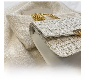 Macro detail of white tweed chain bag with gold sequins and metallic square lock