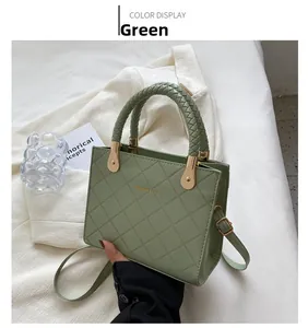 Detail of olive green quilted handbag with woven handle and gold drop-shaped metal hardware