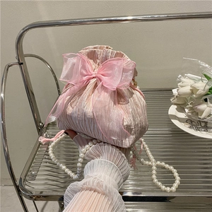 Pink pleated drawstring bucket bag with large organza bow and white pearl shoulder strap