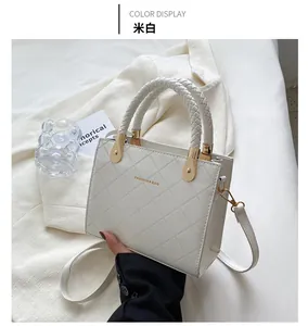 Close-up of beige quilted leather handbag with woven handle and gold hardware