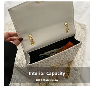 Interior view of white tweed chain bag showing storage for lipstick and cosmetics