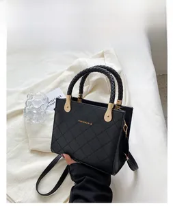 Detail of black quilted tote bag with golden hardware and fashion lettering design
