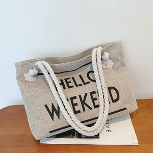 Chic beige woven tote bag with Hello Weekend print and white rope tassel handles