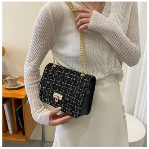 Detail of tweed flap bag with gold chain strap and metal lock shown in lifestyle setting