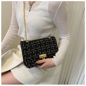Close-up of vintage tweed shoulder bag with gold metal clasp and chain strap