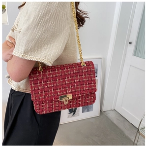 Detail of red tweed shoulder bag with gold chain strap and metallic twist lock clasp
