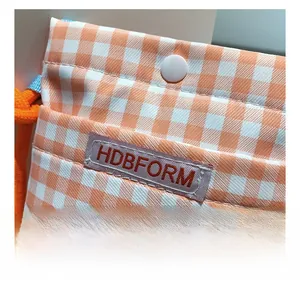 Detail der orange-weiß karierten Canvas-Handytasche mit Druckknopf und HDBFORM-Label