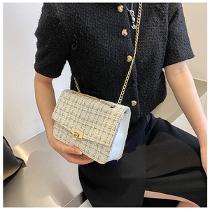 On-body view of a white tweed crossbody bag with gold chain and metal lock