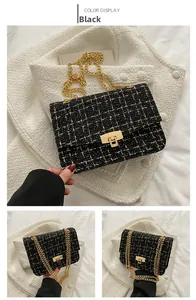Detail of black tweed crossbody bag with gold chain strap and textured woven fabric