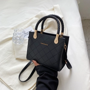 Quilted black handbag with woven handles and gold lettering shown from a front angle