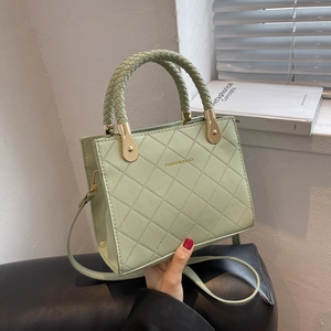 Chic light green quilted square handbag with woven handles and golden metal hardware