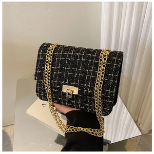 Detail of tweed crossbody bag with golden metal buckle and woven chain strap