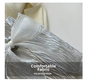 Detail of silver pleated fabric bag featuring an elegant translucent organza bow