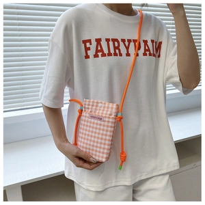 Detail der orangefarbenen Canvas-Handytasche mit Seilriemen und Metall-Druckknopfverschluss