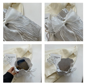 Detail of silver pleated bucket bag with organza bow showing internal storage capacity