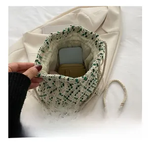Interior view showing the capacity of the green woven bucket bag for a phone and wallet