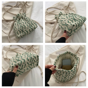 Detail view of woven drawstring bucket bag showing green-white texture and interior space