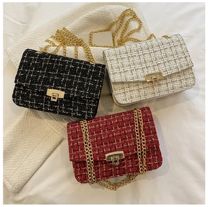 Detail of tweed texture and golden metal buckle on stylish chain crossbody bags
