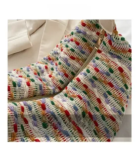 Close-up of colorful woven tote bag showing multi-color fiber texture and gold metal zipper