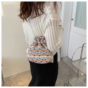 Detail shot of colorful woven drawstring bucket bag showing rich textile textures