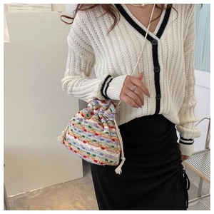 Detail of colorful hand-woven drawstring bucket bag with vibrant bohemian striped texture