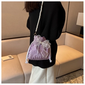 Detail of purple pleated drawstring bucket bag with bow and pearl shoulder strap