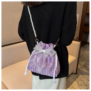 Detail of purple pleated bucket bag with large organza bow and pearl shoulder strap