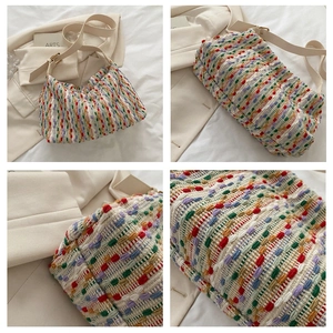 Detail view of a multi-color woven tote bag with a minimalist shoulder strap design