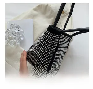 Close-up of black bucket bag featuring sparkling silver rhinestones and leather handles