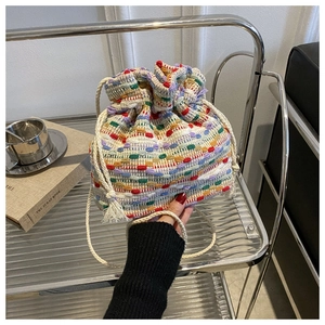Detail of colorful woven bucket bag with drawstring closure and soft cotton texture